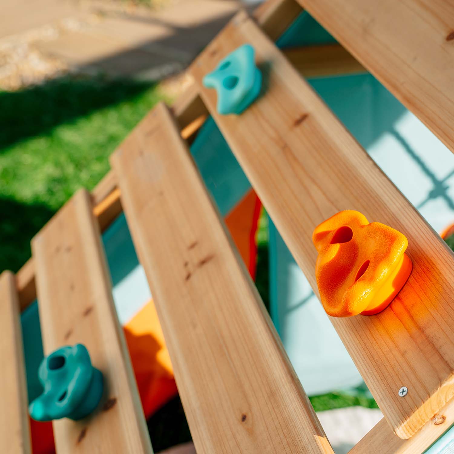 Close-up shot of colorful rock wall in Plum Play's My First Wooden Playcentre Climbing Frame
