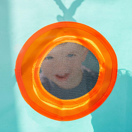 A toddler peeking through the net window of Plum's My First Wooden Playcentre