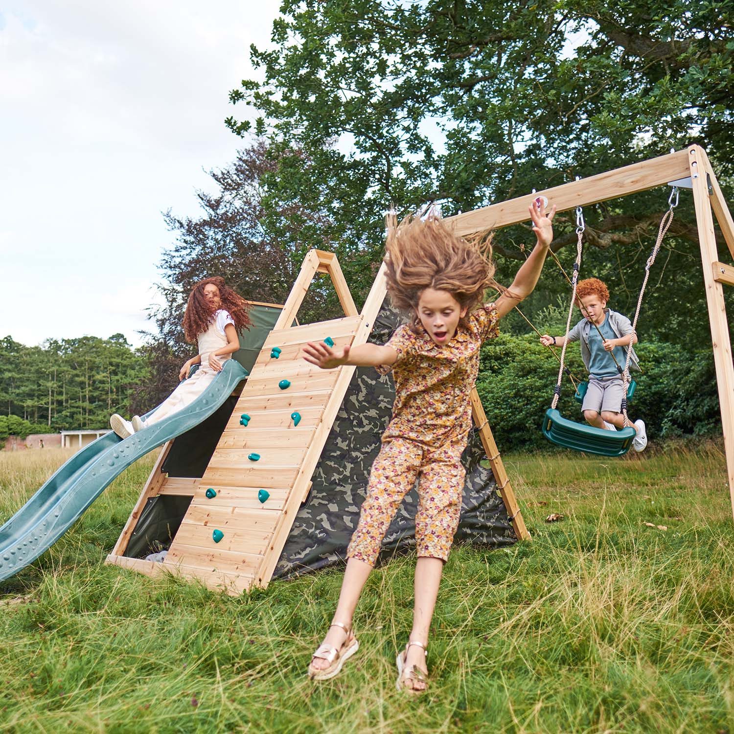 Children playing in the Plum Play's Climbing Pyramid Wooden Climbing Frame with Swings
