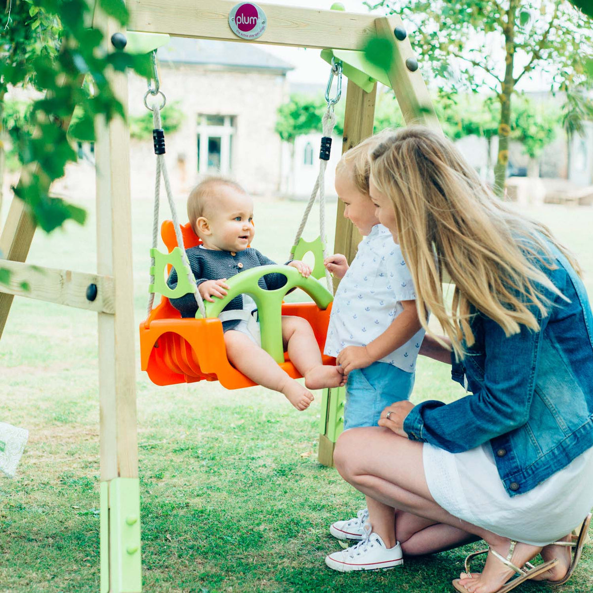 Mom and children playing in Plum Play's 3-in-1 Wooden Growing Swing Set