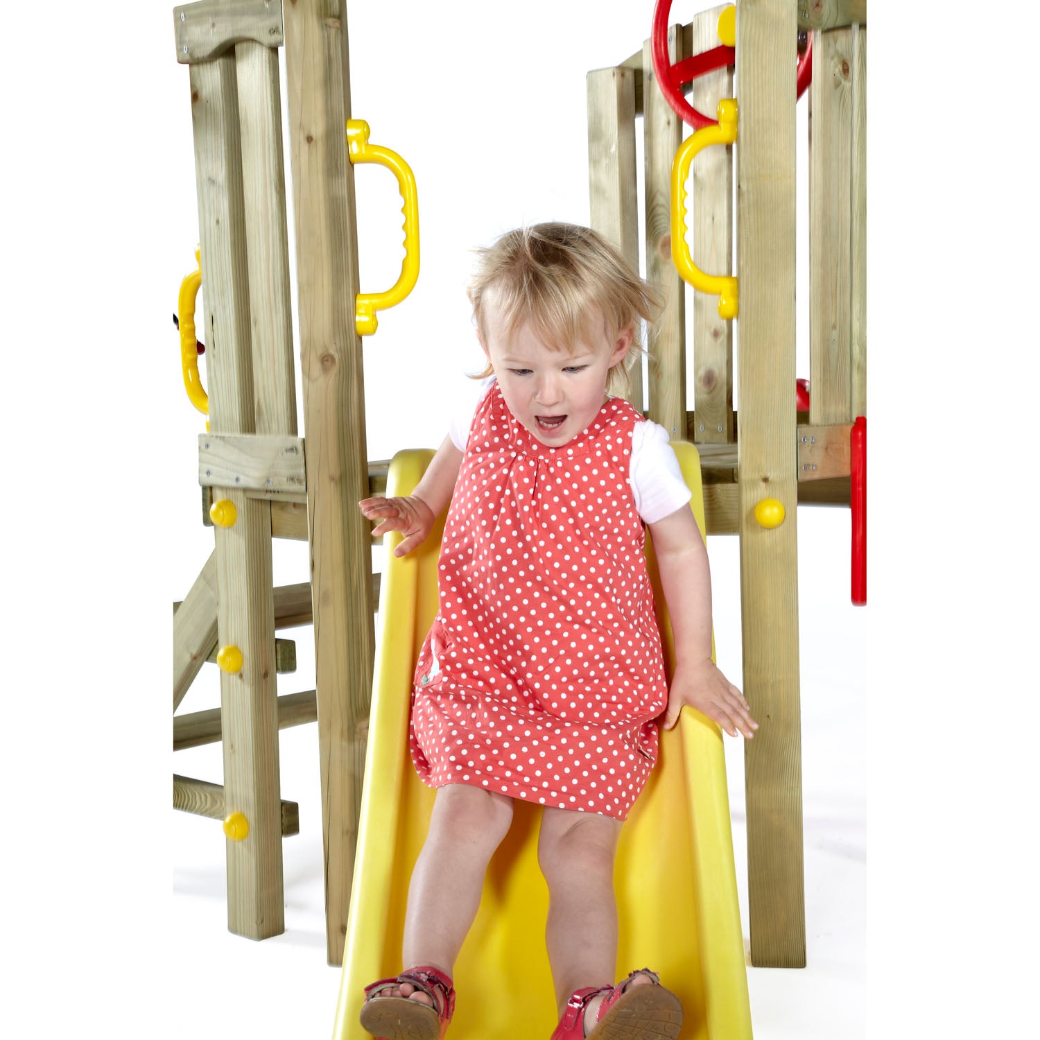 A baby girl sliding in Plum Play's Toddlers Tower Wooden Climbing Frame