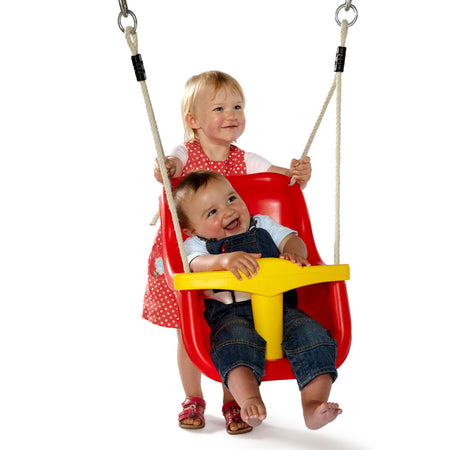 A baby girl holding the swing while an infant sits on it in Plum Play's Toddlers Tower Wooden Climbing Frame