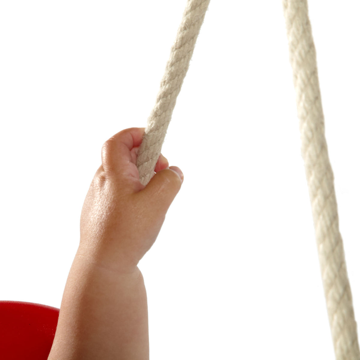 Close-up of a baby's hand holding the rope in the swing set of Plum Play's Toddlers Tower Wooden Climbing Frame