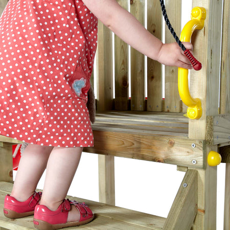 A toddler holding the yellow safety handle while climbing the wooden platform of Plum Play's Toddlers Tower Wooden Climbing Frame