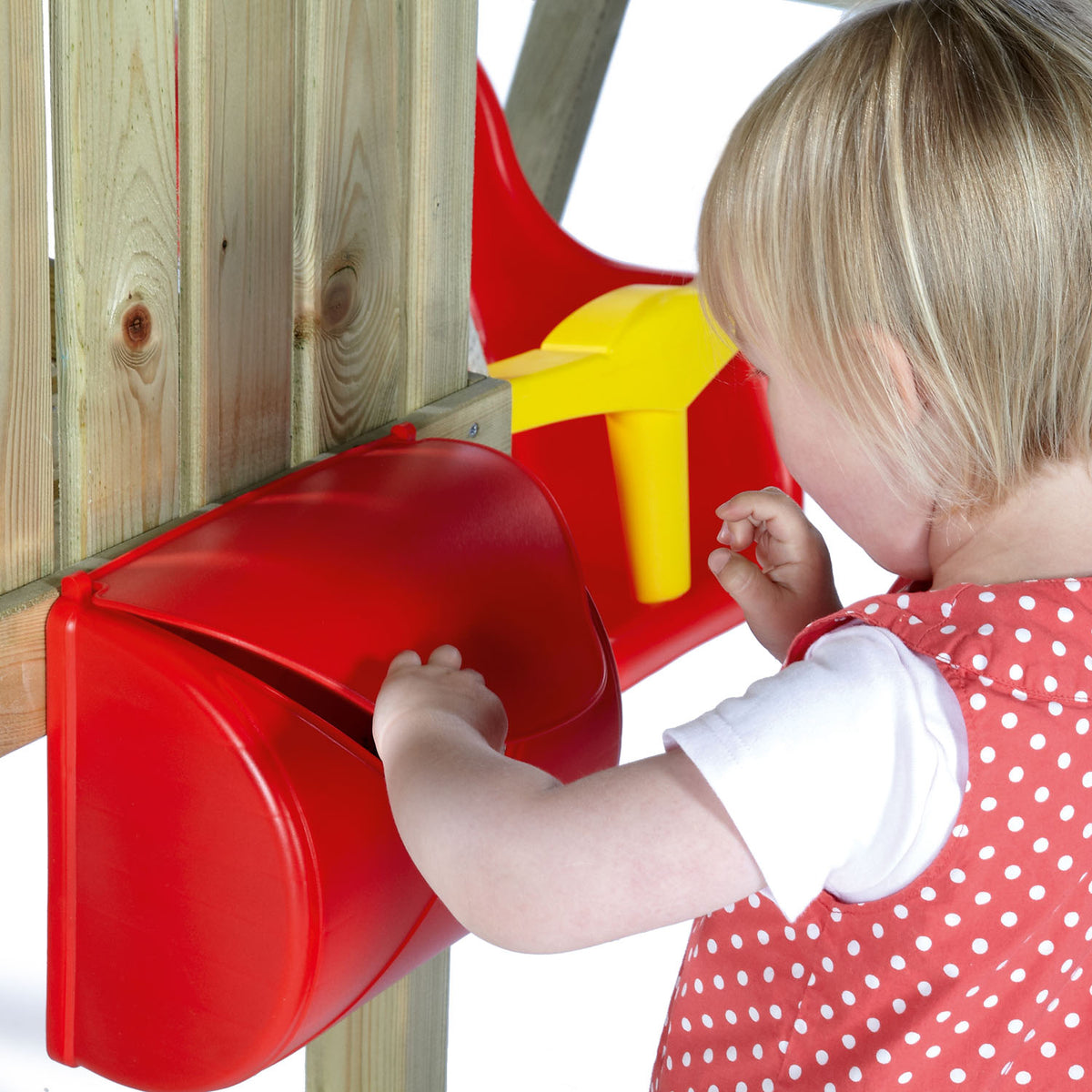 A toddler opening the red box accessory in Plum Play's Toddlers Tower Wooden Climbing Frame