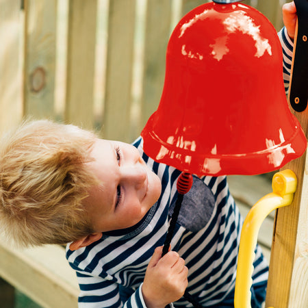 A young boy playing the bell in Plum Play's Toddlers Tower Wooden Climbing Frame