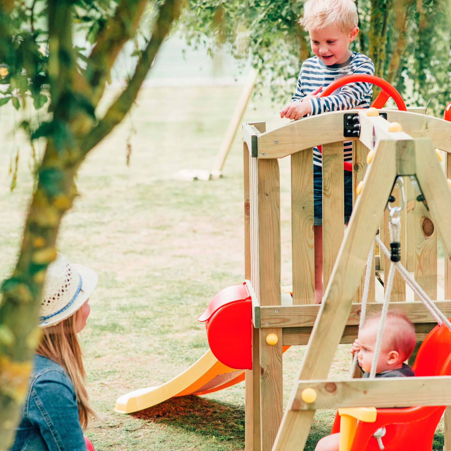 Mom and two children playing in the Plum Play's Toddlers Tower Wooden Climbing Frame