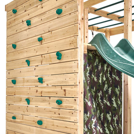 Rock wall with colored hand and foot grips at the side of Plum Play's Wooden Climbing Cube
