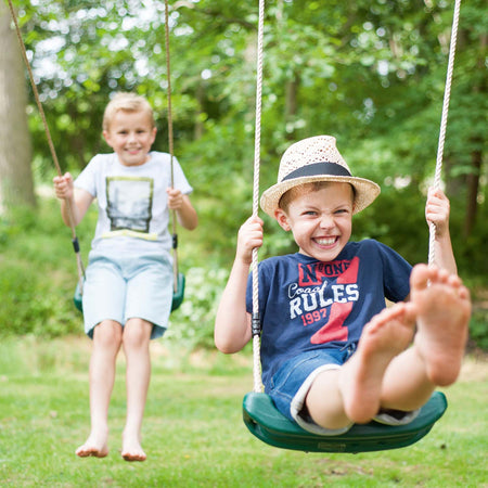 Children having fun swinging in Plum Play's Gibbon Wooden Swing Set