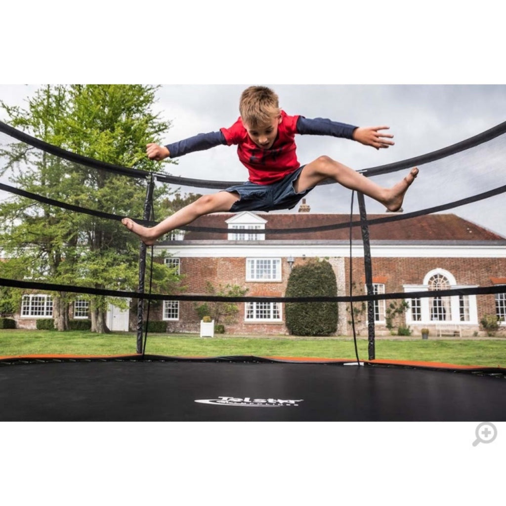 Boy jumping on 9x13ft Telstar Jump Capsule Trampoline