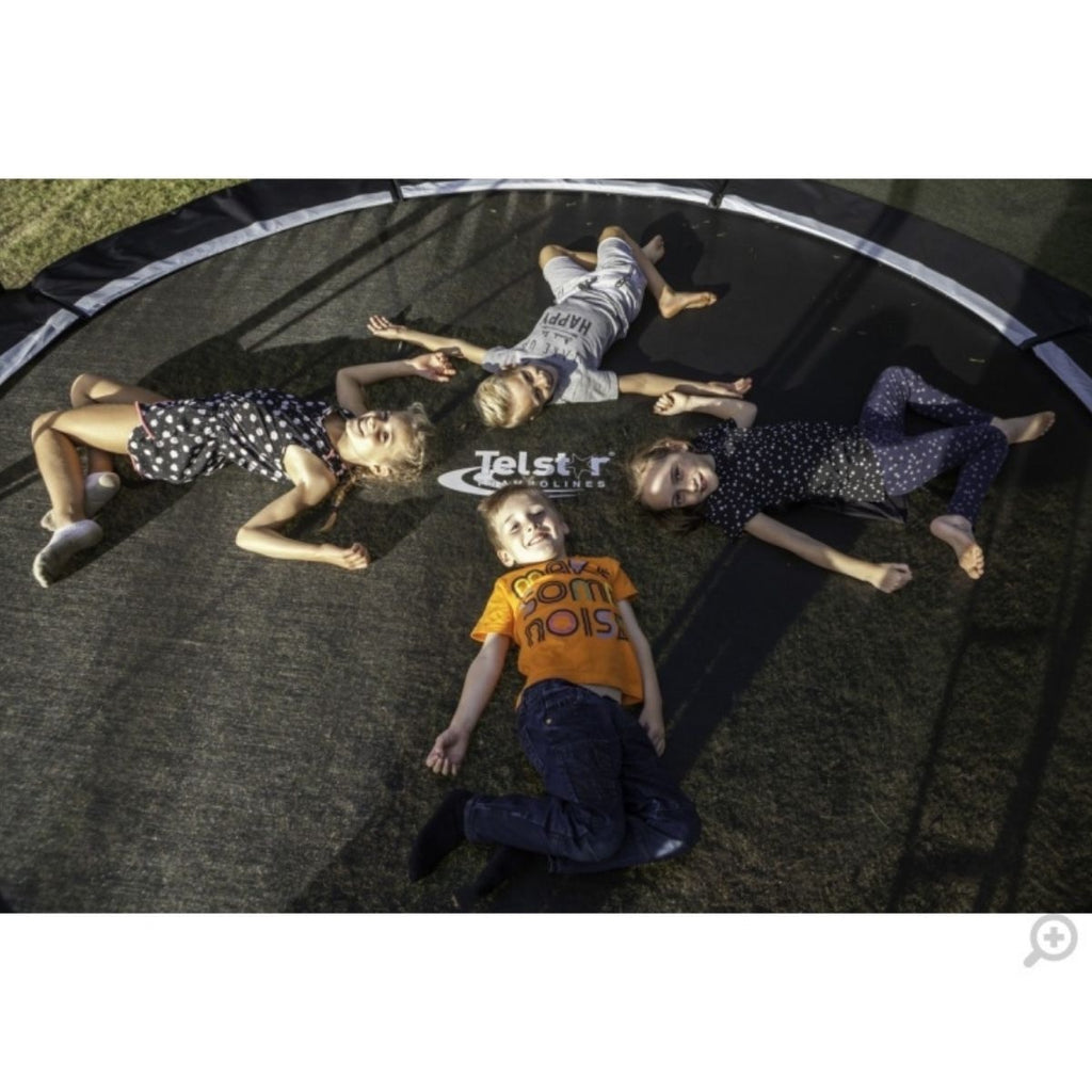 Kids lying on Telstar Orbit Trampoline