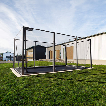 Acon X Trampoline installed flush with ground level in residential backyard setting, demonstrating professional in-ground installation option for seamless landscape integration.