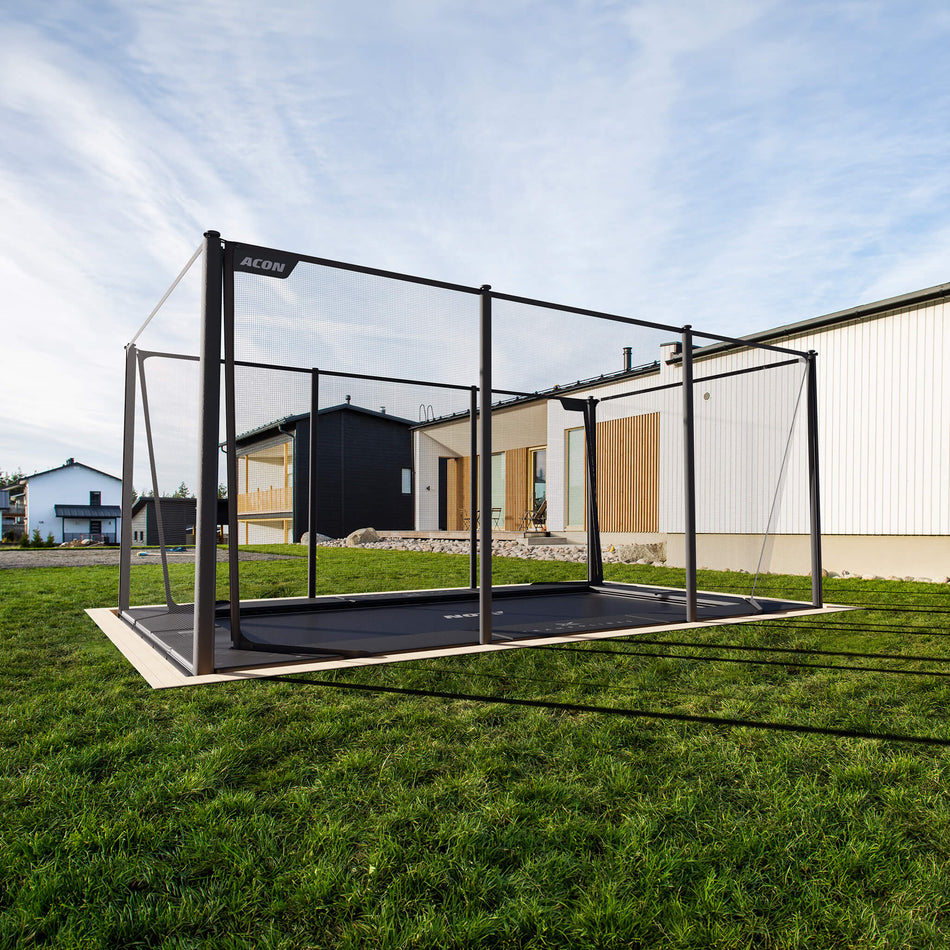 Acon X Trampoline installed flush with ground level in residential backyard setting, demonstrating professional in-ground installation option for seamless landscape integration.