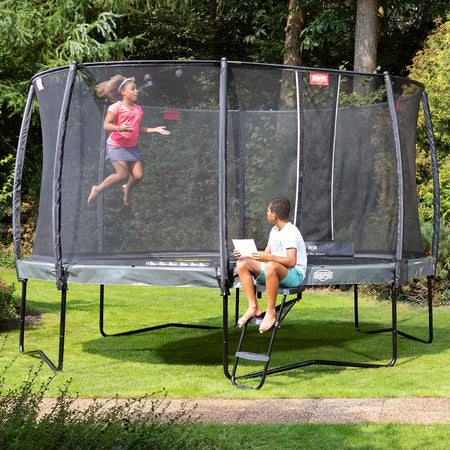 Two kids playing on a BERG Elite Trampoline with Ladder