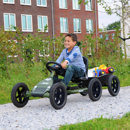 Boy riding a BERG Buddy Go-Kart with BERG Trailer Large attached