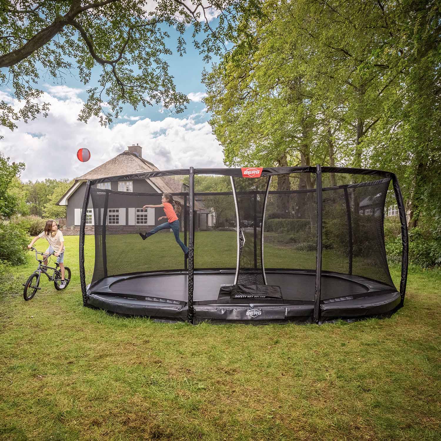 children playing in BERG Grand Champion InGround Oval Trampoline with Safety Net Deluxe