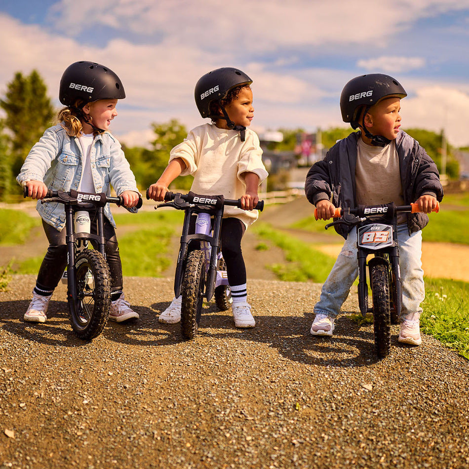 Three children wearing BERG Helmet while riding the BERG Biky balance bike