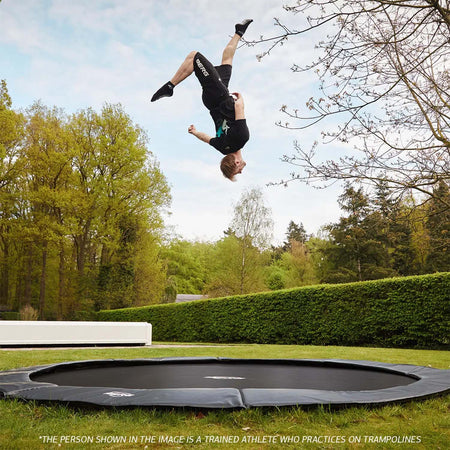 trained athlete performing acrobatic routine in BERG SPORTS Champion FlatGround Round Trampoline