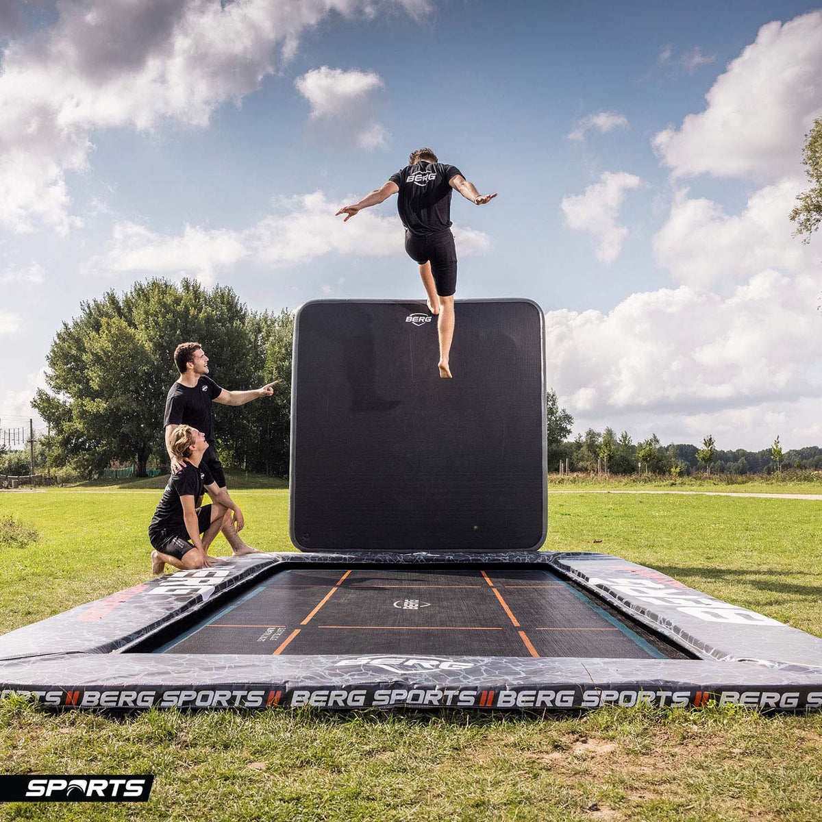 trained athlete bouncing high on a BERG SPORTS Ultim Pro Bouncer FlatGround Rectangular Trampoline with AeroWall